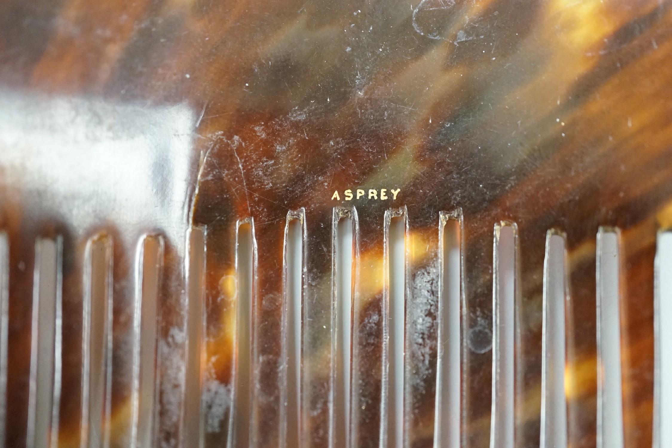 An early 20th century 9ct and mother of pearl mounted tortoiseshell hair comb, by Murrle Bennett & Co, width 93mm and one other tortoiseshell hair comb by Asprey.